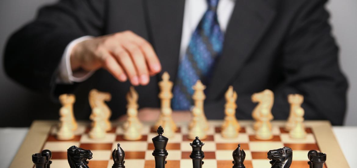 Man in suit behind chessboard