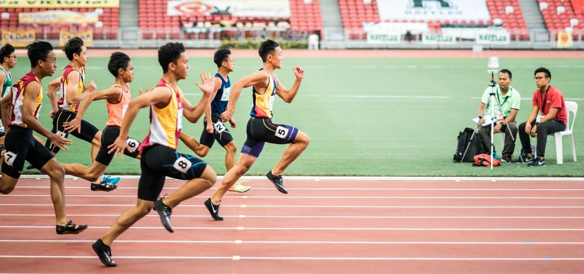 Men racing towards the finish line on a track