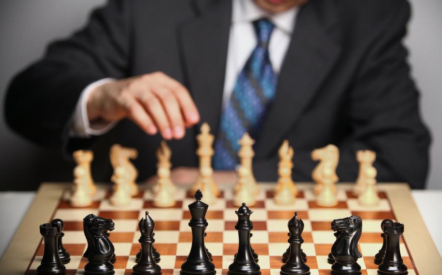 Man in suit behind chessboard