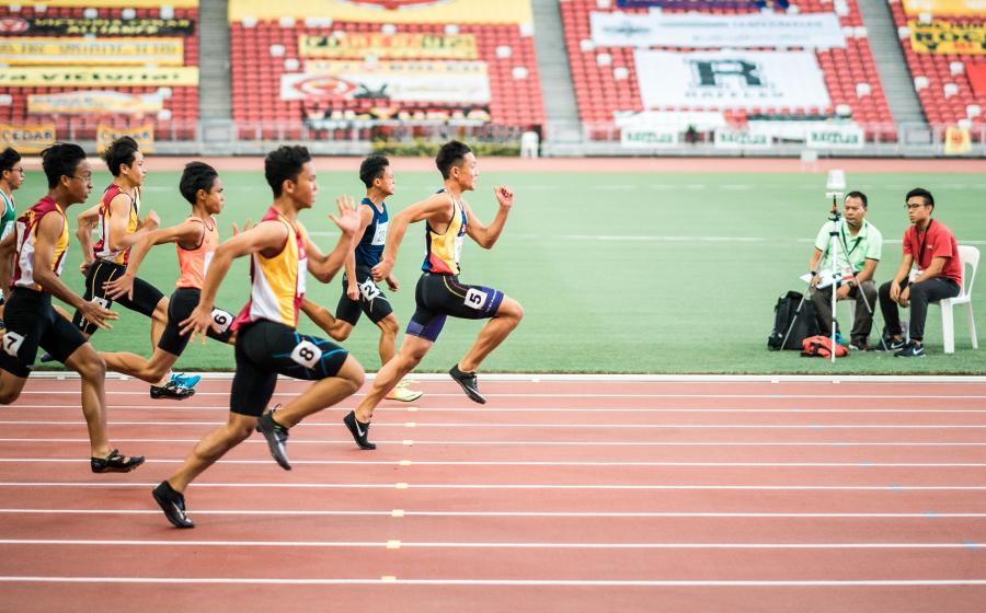 Men racing towards the finish line on a track