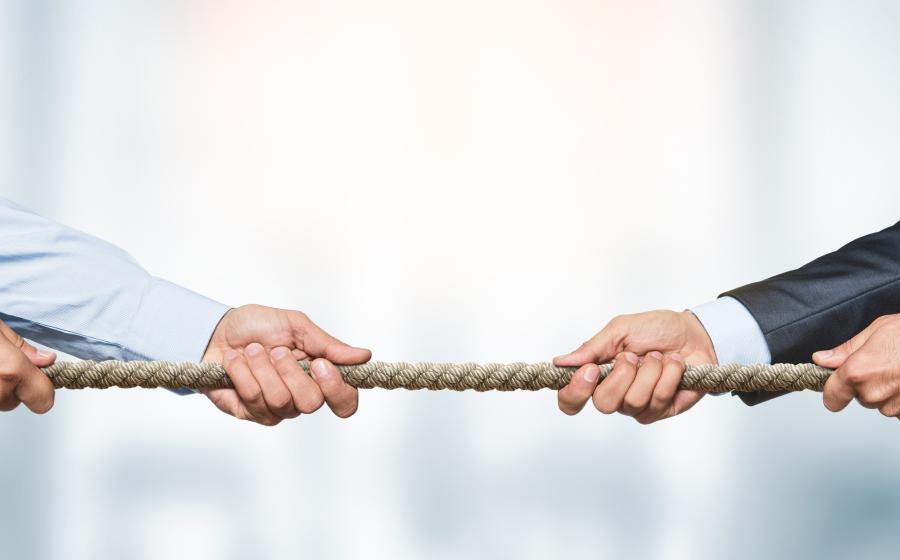 Men's hands holding rope for tug of war